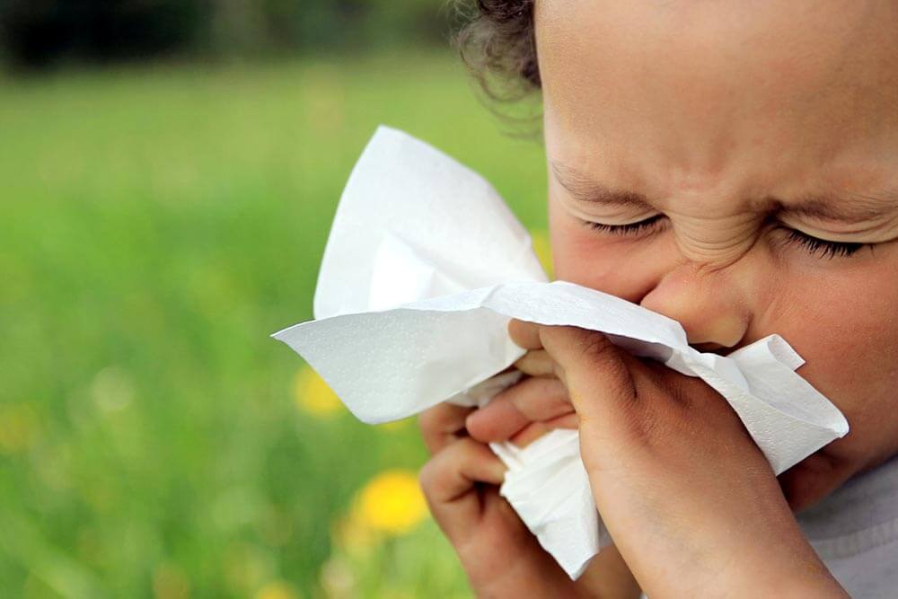 child blowing nose after catching a cold